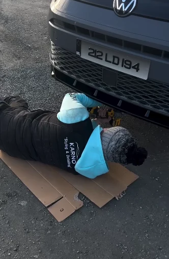 Oisin, owner of Karno Auto Styling, working on a vehicle during a mobile detailing job